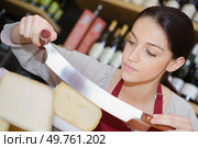 a saleswoman holding cutting cheese. Стоковое фото, агентство Ingram Publishing / Фотобанк Лори