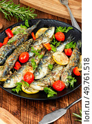 Sardines roasted with cherry tomatoes rosemary and lemon on rustic wooden table.. Grilled or baked sardines. Стоковое фото, агентство Ingram Publishing / Фотобанк Лори
