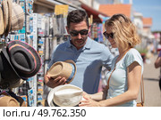 couple at outdoor summer market looking at hats. Стоковое фото, агентство Ingram Publishing / Фотобанк Лори