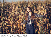 A joyful young woman delightfully poses amidst a lush, expansive cornfield, radiating pure happiness and a profound connection with the beauty of nature all around her on that sunny day. A Joyful Moment in a Beautiful Cornfield on a Bright and Sunny Day Filled with Fun and Energy. Стоковое фото, агентство Ingram Publishing / Фотобанк Лори