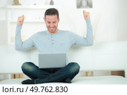 man sitting on sofa with arms up posture. Стоковое фото, агентство Ingram Publishing / Фотобанк Лори
