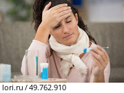 young woman with thermometer taking her temperature. Стоковое фото, агентство Ingram Publishing / Фотобанк Лори