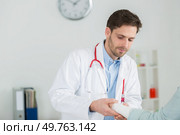 doctor fixing female patients wrist splint. Стоковое фото, агентство Ingram Publishing / Фотобанк Лори