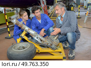 Engineers looking at aircraft landing gear. Стоковое фото, агентство Ingram Publishing / Фотобанк Лори