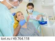 dentist curing a woman patient in the dental office. Стоковое фото, агентство Ingram Publishing / Фотобанк Лори