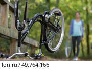 female cyclist returning to upturned bicycle carrying wheel. Стоковое фото, агентство Ingram Publishing / Фотобанк Лори
