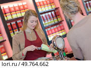 cheerful young woman selling nuts and pastry in shop. Стоковое фото, агентство Ingram Publishing / Фотобанк Лори