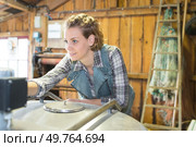 Woman pressing controls of metal container. Стоковое фото, агентство Ingram Publishing / Фотобанк Лори