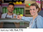 confectioner selling ice cream to young woman in the shop. Стоковое фото, агентство Ingram Publishing / Фотобанк Лори