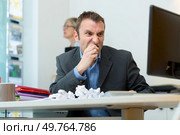 frustrated man sat at computer with screwed up paper balls. Стоковое фото, агентство Ingram Publishing / Фотобанк Лори