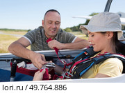 adventurous woman being strapped into sailplane. Стоковое фото, агентство Ingram Publishing / Фотобанк Лори