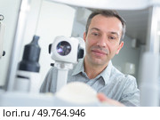 optometrist with non contact tonometer checking patient intraocular pressure. Стоковое фото, агентство Ingram Publishing / Фотобанк Лори
