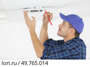 workman marking a spot with pencil to drill a hole. Стоковое фото, агентство Ingram Publishing / Фотобанк Лори