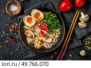 A bowl filled with steaming noodles topped with slices of meat, boiled eggs, and assorted vegetables.. Bowl of Noodles With Meat, Eggs, and Vegetables. Стоковое фото, агентство Ingram Publishing / Фотобанк Лори