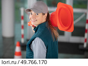 happy female builder holding traffic cone. Стоковое фото, агентство Ingram Publishing / Фотобанк Лори