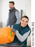female worker pouring from industrial container. Стоковое фото, агентство Ingram Publishing / Фотобанк Лори