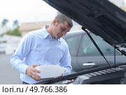 man filling fresh water into the windscreen wiper system. Стоковое фото, агентство Ingram Publishing / Фотобанк Лори
