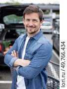happy man in supermarket carpark with arms crossed. Стоковое фото, агентство Ingram Publishing / Фотобанк Лори
