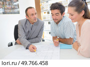 worker showing couple the floor plan. Стоковое фото, агентство Ingram Publishing / Фотобанк Лори