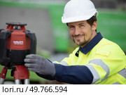 portrait of surveyor next to theodolite machine. Стоковое фото, агентство Ingram Publishing / Фотобанк Лори