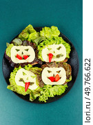 Funny monster face on Halloween sandwich toast. Halloween. Top view.. Mini sandwiches with monster faces. Стоковое фото, агентство Ingram Publishing / Фотобанк Лори