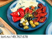 Greek appetizer of sun-dried tomatoes, black and green olives and stuffed cheese with marinated red peppers.. Tasty antipasto mix. Стоковое фото, агентство Ingram Publishing / Фотобанк Лори