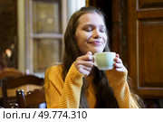 In a beautifully cozy setting filled with warmth and charm, a young woman gently savors a steaming cup of her favorite warm beverage, radiating a sense of deep contentment and profound relaxation. Savoring a Cozy Moment While Enjoying a Warm and Comforting Drink of Your Choice. Стоковое фото, агентство Ingram Publishing / Фотобанк Лори