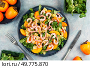 Delicious fresh seafood salad with prawns, persimmon, kiwi and herbs. Top view.. Healthy salad with shrimp prawns, persimmon and green salad. Стоковое фото, агентство Ingram Publishing / Фотобанк Лори