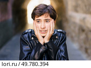 In a bustling and vibrant urban alley, a teenager wearing a trendy leather jacket showcases a compelling mix of surprise and anxiety, capturing the intense raw emotions and dynamic drama of city life. A Young Individual Wearing a Leather Jacket Conveying Strong Emotions in an Alleyway. Стоковое фото, агентство Ingram Publishing / Фотобанк Лори