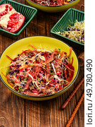 Salad of sprouted alfalfa, beans, red radish with pomegranate seeds and black carrots on wooden rustic background.. Sprouts and pomegranate salad. Стоковое фото, агентство Ingram Publishing / Фотобанк Лори