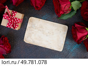 Crimson red rose flowers bouquet with gift box and epmty car for text, Valentine’s Day background. Crimson red rose flowers. Стоковое фото, агентство Ingram Publishing / Фотобанк Лори
