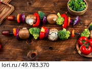 Colorful grilled summer seasonal vegetables skewers on rustic wooden table. Preparation of vegetable kebabs. Vegan food concept.. Uncooked BBQ Vegetable Skewers. Стоковое фото, агентство Ingram Publishing / Фотобанк Лори