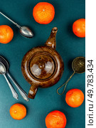 Cups of tea, teapot, mandarins or tangerines. Clementines tea flavor, tea with fruit. Top view.. Glass kettle of tangerines tea. Стоковое фото, агентство Ingram Publishing / Фотобанк Лори