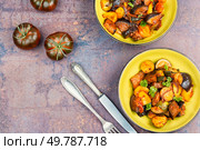 Ratatouille or stewed potatoes, eggplants, zucchini, onions, carrots in spicy sauce with greens. Space for text.. Delicious vegetable stew in a bowl on the table. Стоковое фото, агентство Ingram Publishing / Фотобанк Лори