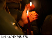 Истра. Горящая свеча в руке во время Пасхальной службы в Cтавропигиальном Воскресенском Новоиерусалимском мужском монастыре. (2023 год). Стоковое фото, фотограф Дмитрий Киселёв / Фотобанк Лори
