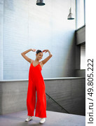 A talented dancer confidently poses in a vibrant red outfit against a stunning modern architecture backdrop, creating a mesmerizing visual experience that showcases the beauty of dance. An Elegant Dance Pose Captured in a Stunning and Vibrant Red Outfit with Dynamic Movement. Стоковое фото, агентство Ingram Publishing / Фотобанк Лори