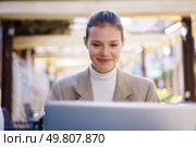 A young professional woman smiles while working on her laptop outdoors, highlighting the positive aspects and benefits of her work environment and the flexibility of telecommuting. A Smiling Woman Working Efficiently on Her Laptop While Enjoying a Beautiful Outdoor Setting. Стоковое фото, агентство Ingram Publishing / Фотобанк Лори