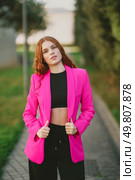 A confident and stylish young woman poses gracefully outdoors, showcasing her vibrant pink blazer that elegantly contrasts her chic black crop top, exuding an undeniable sense of style and attitude. A stylish young woman in a pink blazer and black crop top in a beautiful outdoor setting. Стоковое фото, агентство Ingram Publishing / Фотобанк Лори