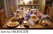 Junk food covering a dining table, untouched. Symbol of a major environmental problem caused by urban overconsumption waste. Abstract image. Стоковое AI-изображение, AI-художник ALLA YURTAYEVA / Фотобанк Лори