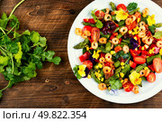 Shrimp and leafy vegetables salad with green asparagus, edible flowers and red caviar on wooden rustic background.. Fresh healthy shrimp salad, modern kitchen. Стоковое фото, агентство Ingram Publishing / Фотобанк Лори