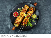Skewers of baked potatoes with bacon and cheese. Roasted potatoes with flavorful sauces.. Potatoes with bacon on skewers, summer barbecue. Стоковое фото, агентство Ingram Publishing / Фотобанк Лори