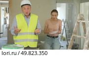 Portrait of perplexed man builder and annoyed gesturing woman, conflict between female architect and contractor at construction site of house being renovated. Стоковое видео, видеограф Яков Филимонов / Фотобанк Лори