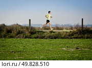 Male runner at sprinting speed training for marathon outdoors on country landscape. Стоковое фото, агентство Ingram Publishing / Фотобанк Лори