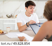 Woman manager tells guy client about specifics of design of microloan, about benefits and advantages. Стоковое фото, фотограф Яков Филимонов / Фотобанк Лори
