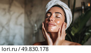 A woman is in the bathroom, washing her face with a cleanser. Стоковое AI-изображение, AI-художник Ярославский Максим / Фотобанк Лори