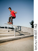 Skateboarder doing a 50-50 grind on rail. Стоковое фото, агентство Ingram Publishing / Фотобанк Лори