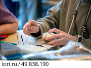 Close-up of a student's hands meticulously shaping a small animal figurine using needle felting techniques during a crafting workshop, surrounded by tools and materials. Стоковое фото, фотограф Ольга Ильина / Фотобанк Лори