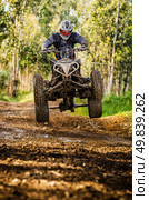 Quad rider jumping on a forest trail. Стоковое фото, агентство Ingram Publishing / Фотобанк Лори
