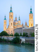 Our Lady of the Pillar Basilica with Ebro River at dusk Zaragoza, Spain. Стоковое фото, агентство Ingram Publishing / Фотобанк Лори