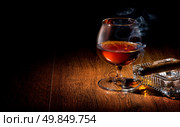 Cognac and cigar on ashtray on a wooden table. Стоковое фото, агентство Ingram Publishing / Фотобанк Лори